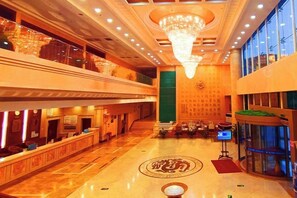 A hotel lobby with a reception desk, a chandelier, and a large window. - Longshan Hotel (Handan)