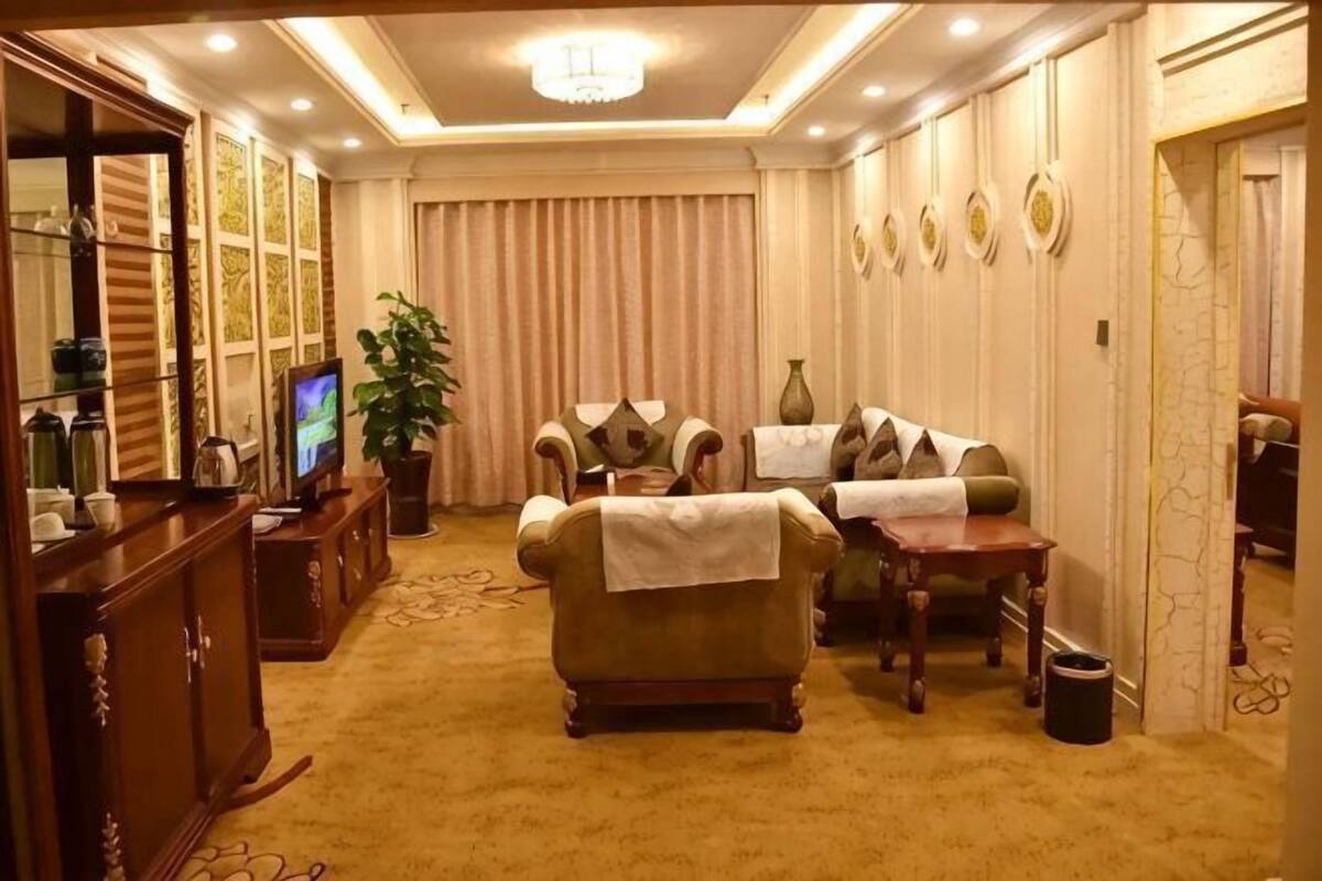 A living room with a sofa, a television, a coffee table, and a dining table with chairs.