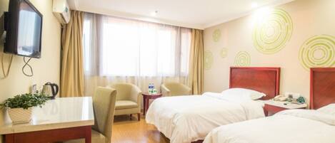 A hotel room with two beds, a desk with a chair, a television, and a window with curtains.