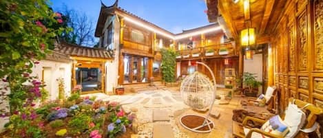 Un edificio tradicional con patio, suelo de piedra y zona de estar con cojines.