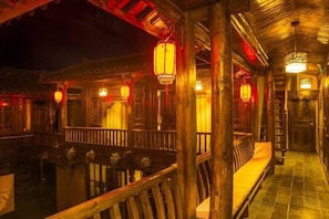 Un bâtiment traditionnel en bois, doté d’un balcon et de lanternes.