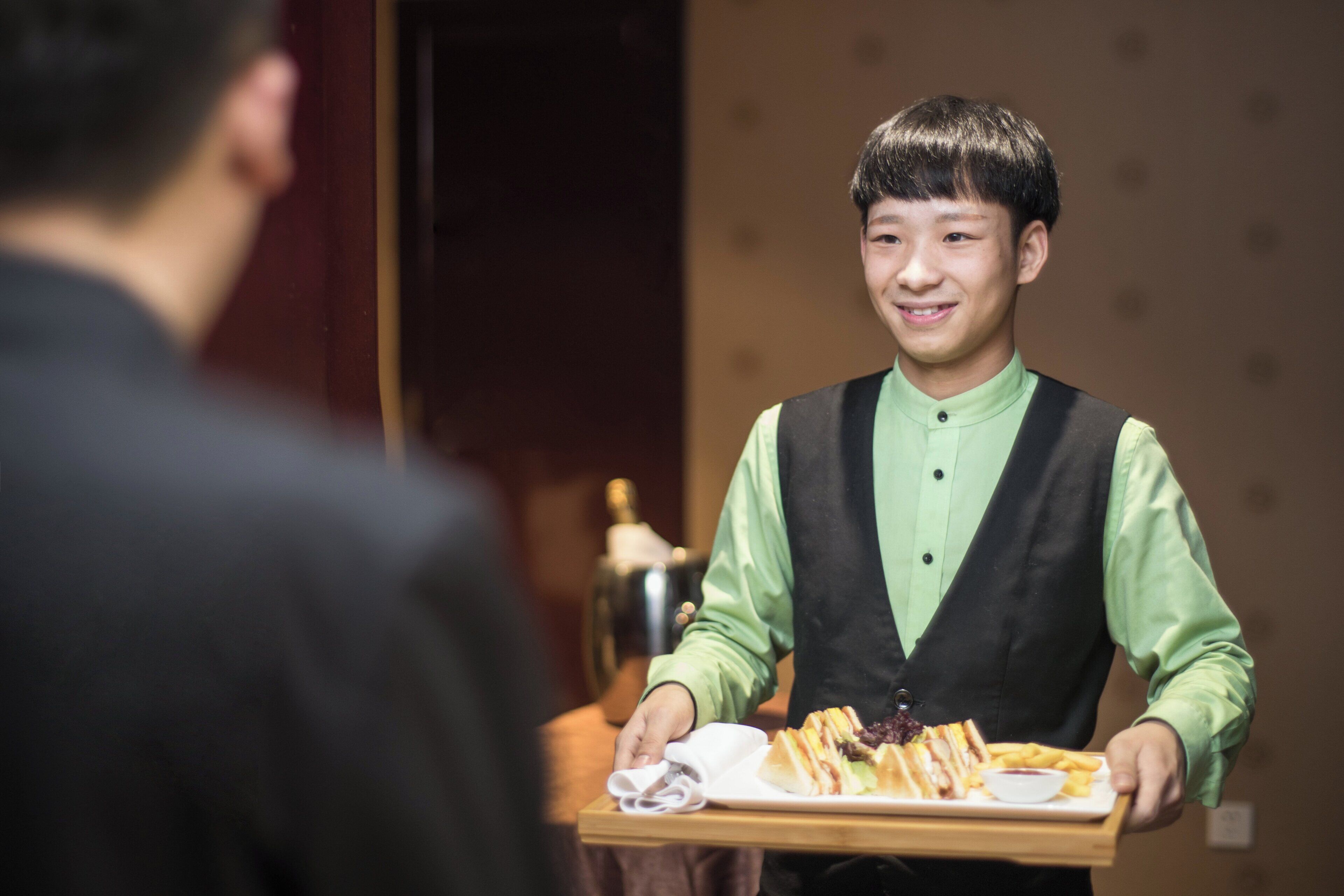 A waiter holding a tray with food and a napkin.