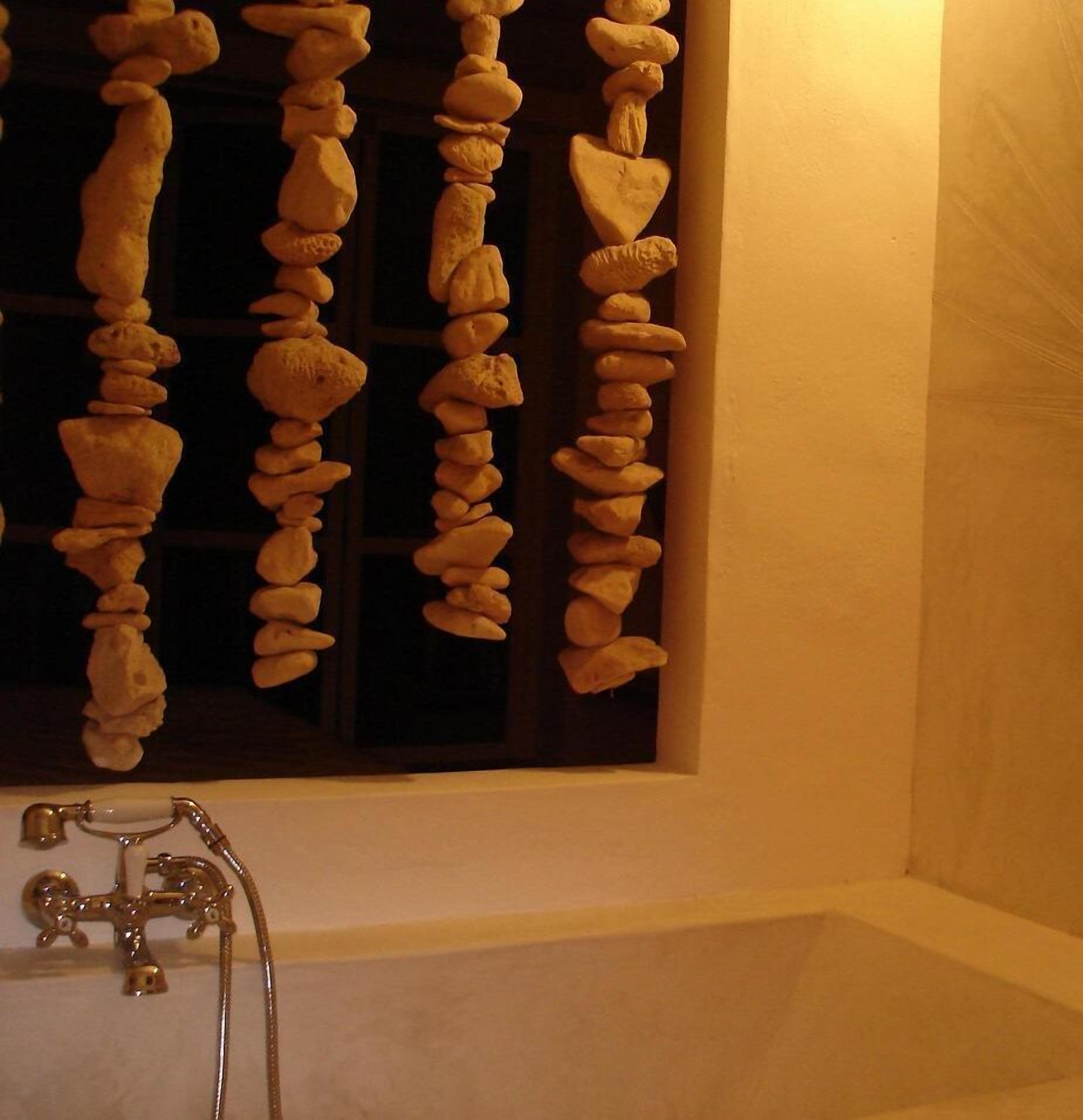 Une salle de bain avec une baignoire, une fenêtre avec un rideau et un porte-serviettes avec des serviettes.
