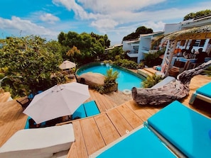 Una piscina al aire libre, sillones reclinables de piscina