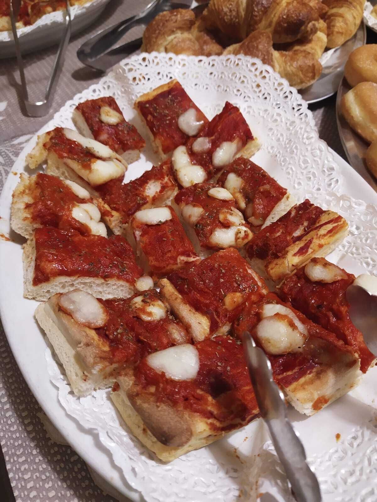 A plate of pizza slices with a knife on it.