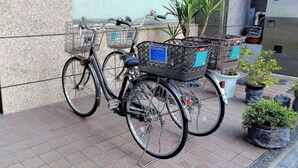 Deux vélos, chacun muni d’un panier, sont garés sur une surface carrelée.