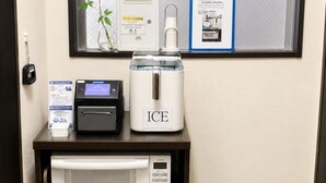 Un four à micro-ondes, un distributeur de glaçons, une balance numérique, une plante et une fenêtre avec vue.