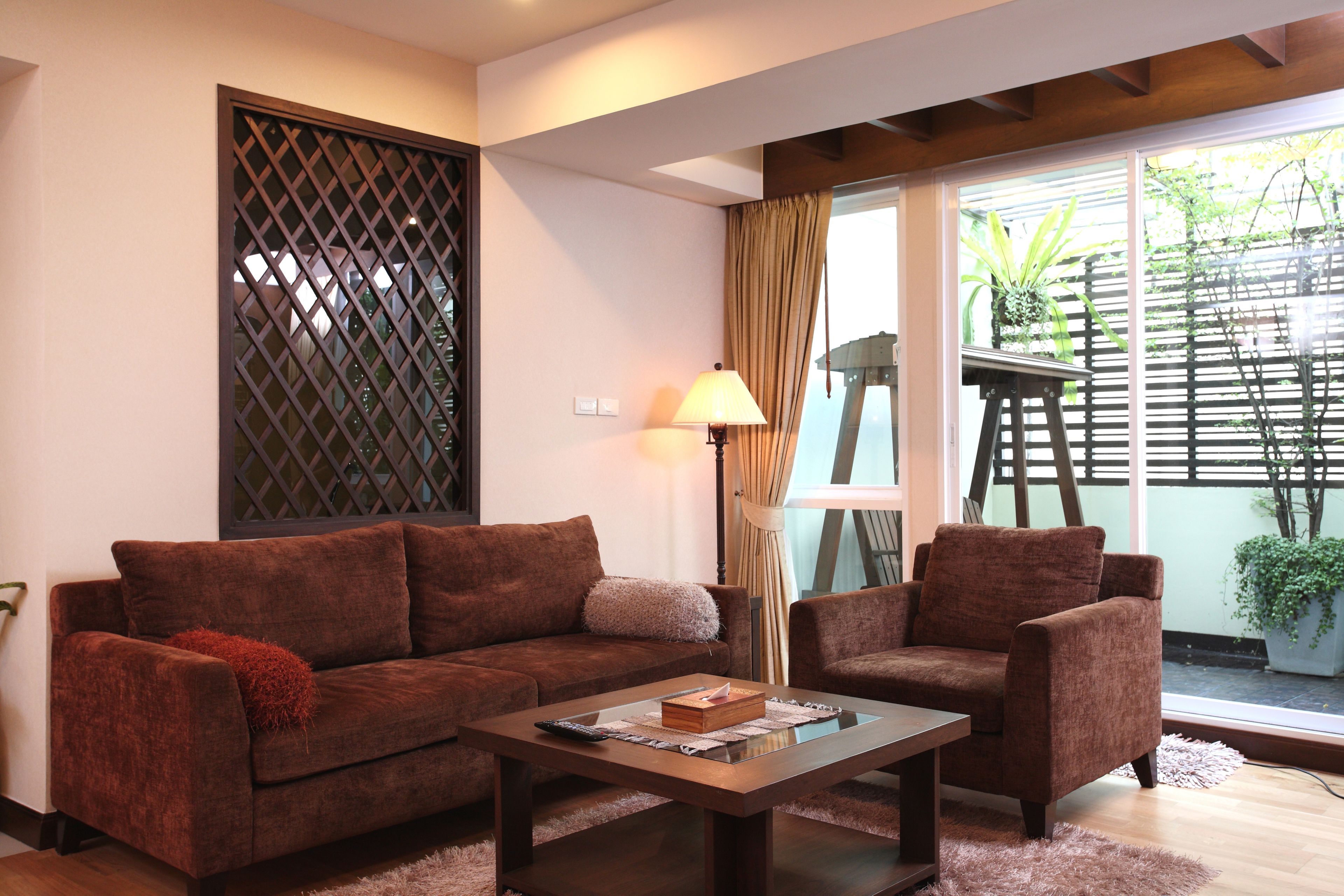 A living room with a brown sofa, a wooden coffee table, and a lamp.