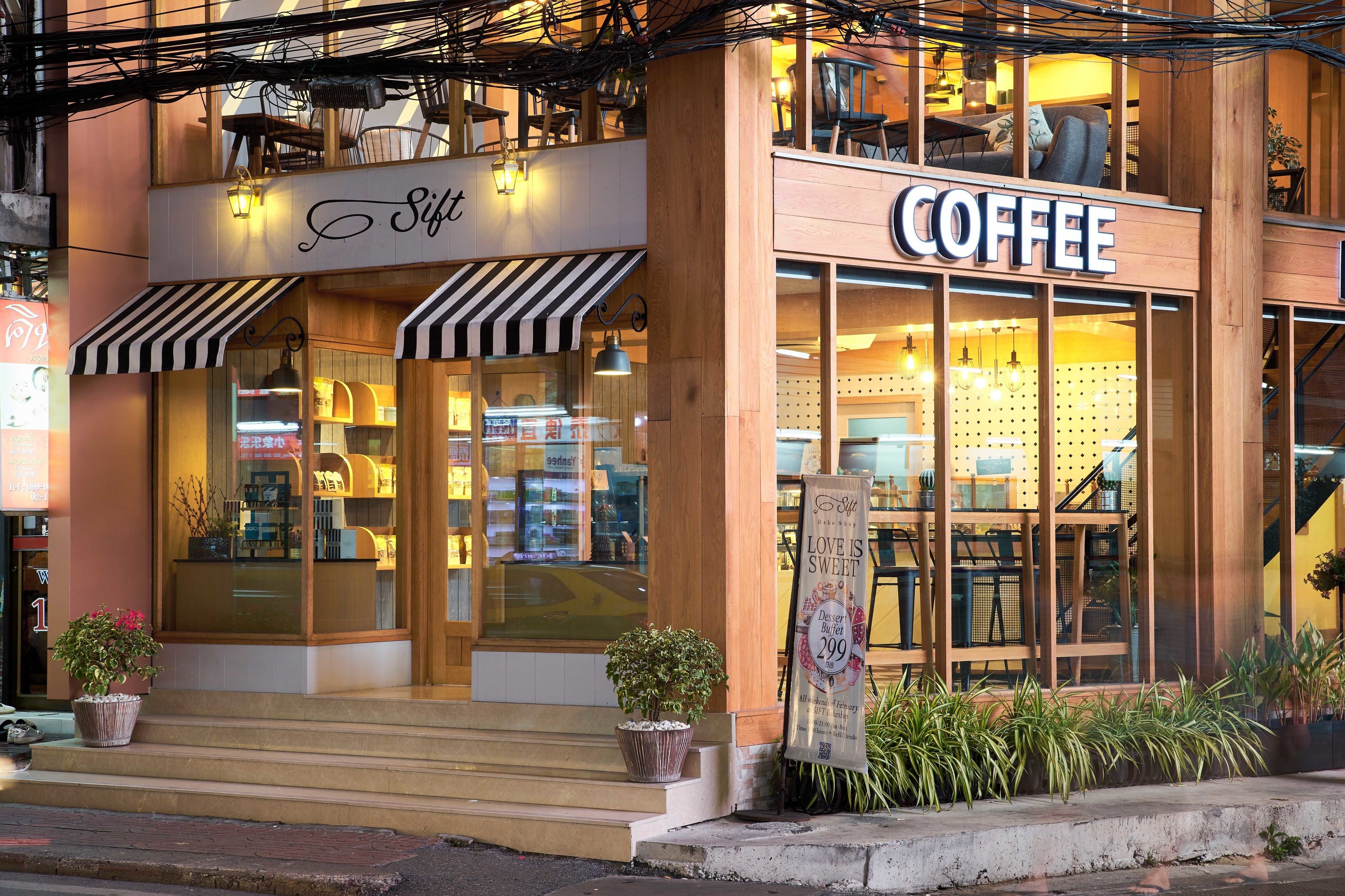 A coffee shop with a wooden facade, a sign reading "Coffee," and a staircase leading to the entrance.