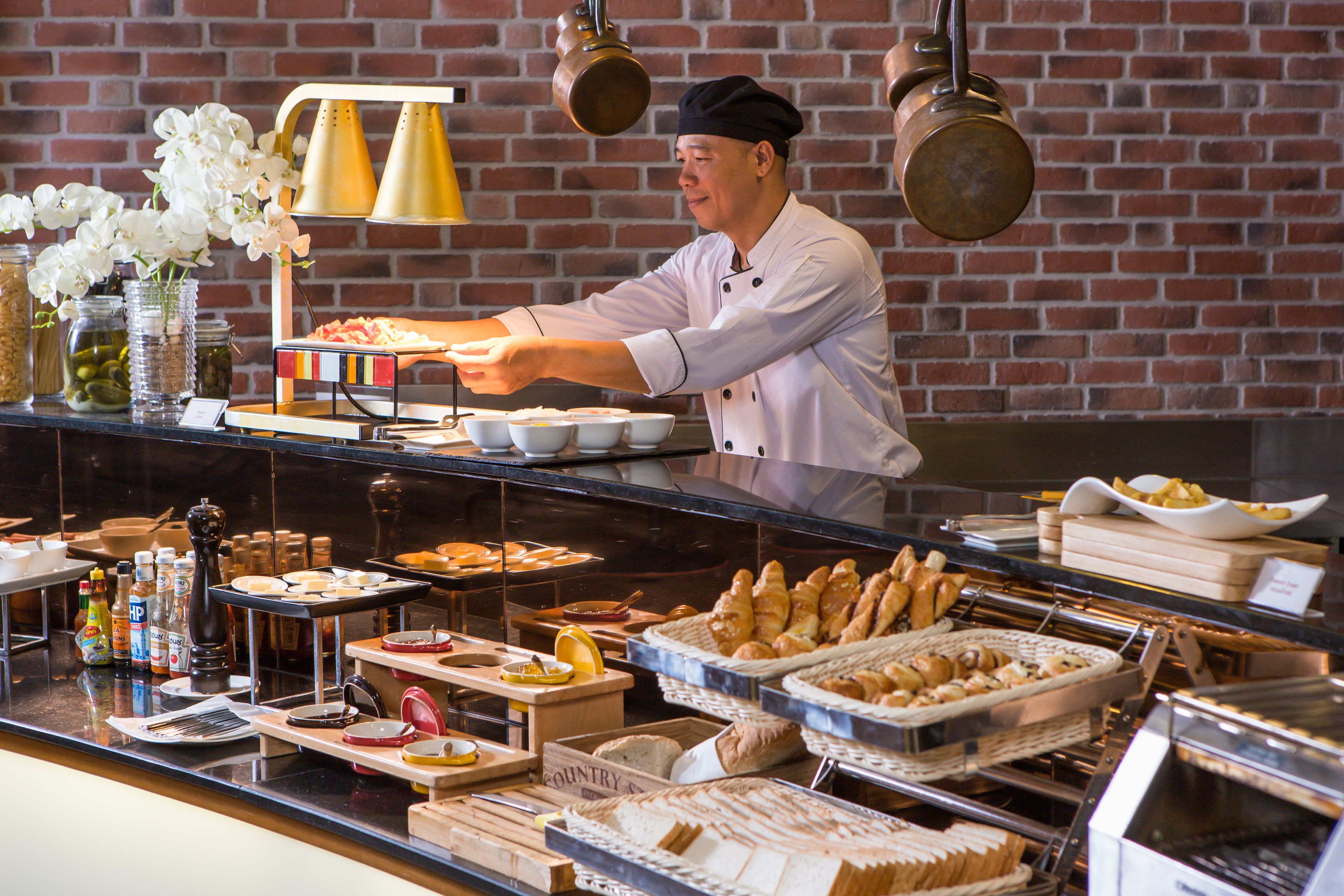 A buffet setup with various food items and condiments.