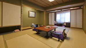 A traditional Japanese room with tatami flooring, a low table, and a sliding door. - Hotel Kanichi (Atami)