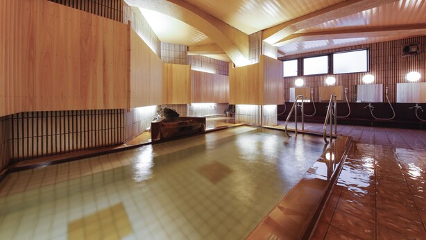 A traditional Japanese onsen with wooden walls and a tiled floor. - Hotel Kanichi (Atami)