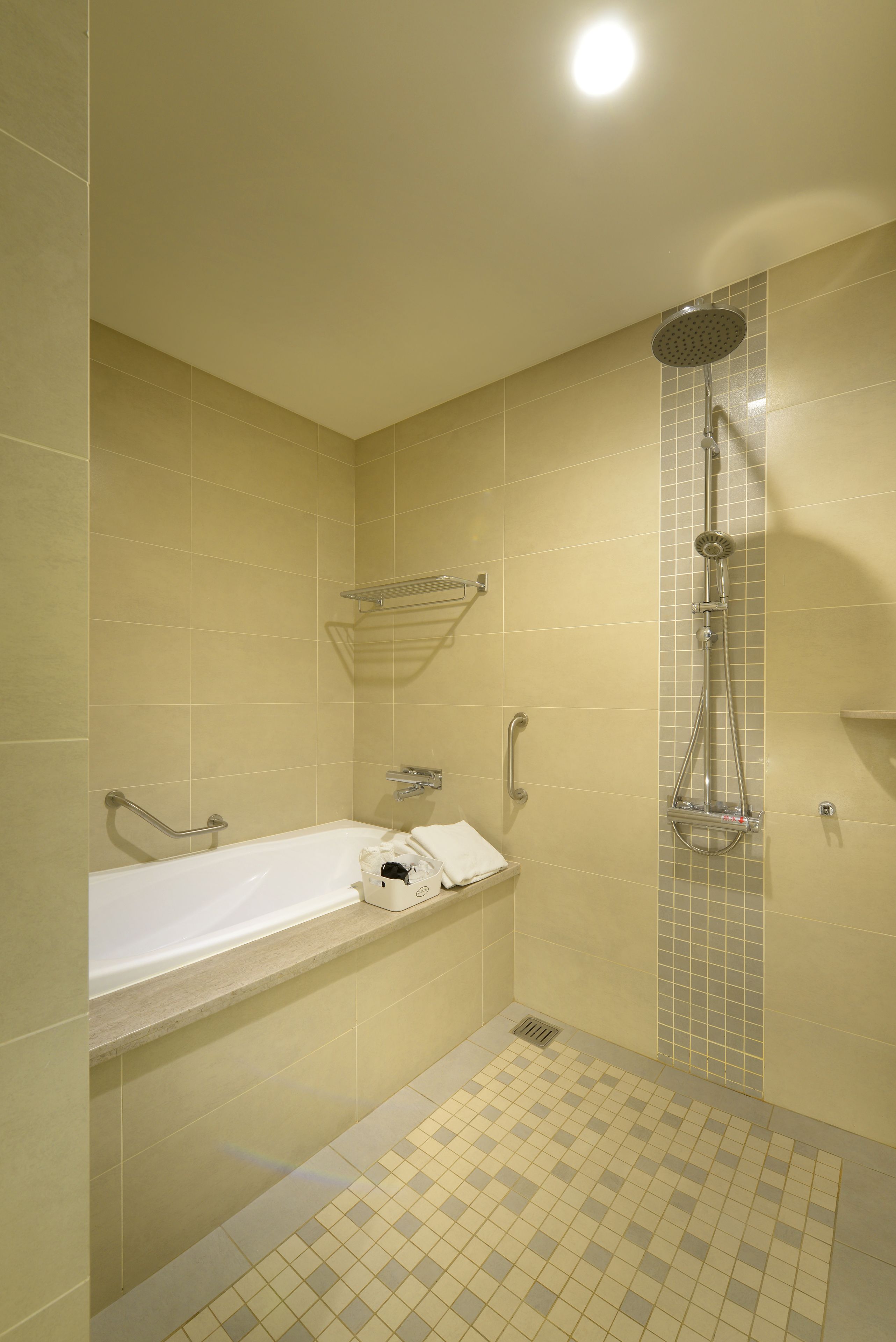 Un baño con bañera, ducha y piso de baldosas.