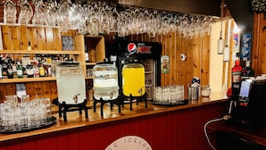 A bar area with a wooden interior, a Pepsi Max refrigerator, and a variety of liquor bottles. - Hellisholar Cottages (Rangárþing eystra)