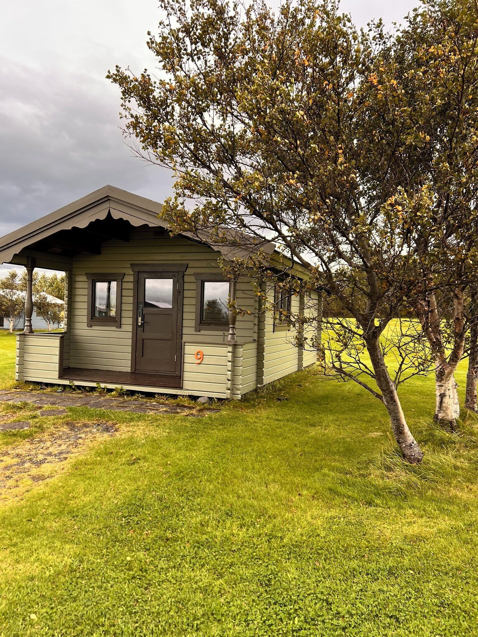 A small, single-story cabin with a gabled roof and a front door.