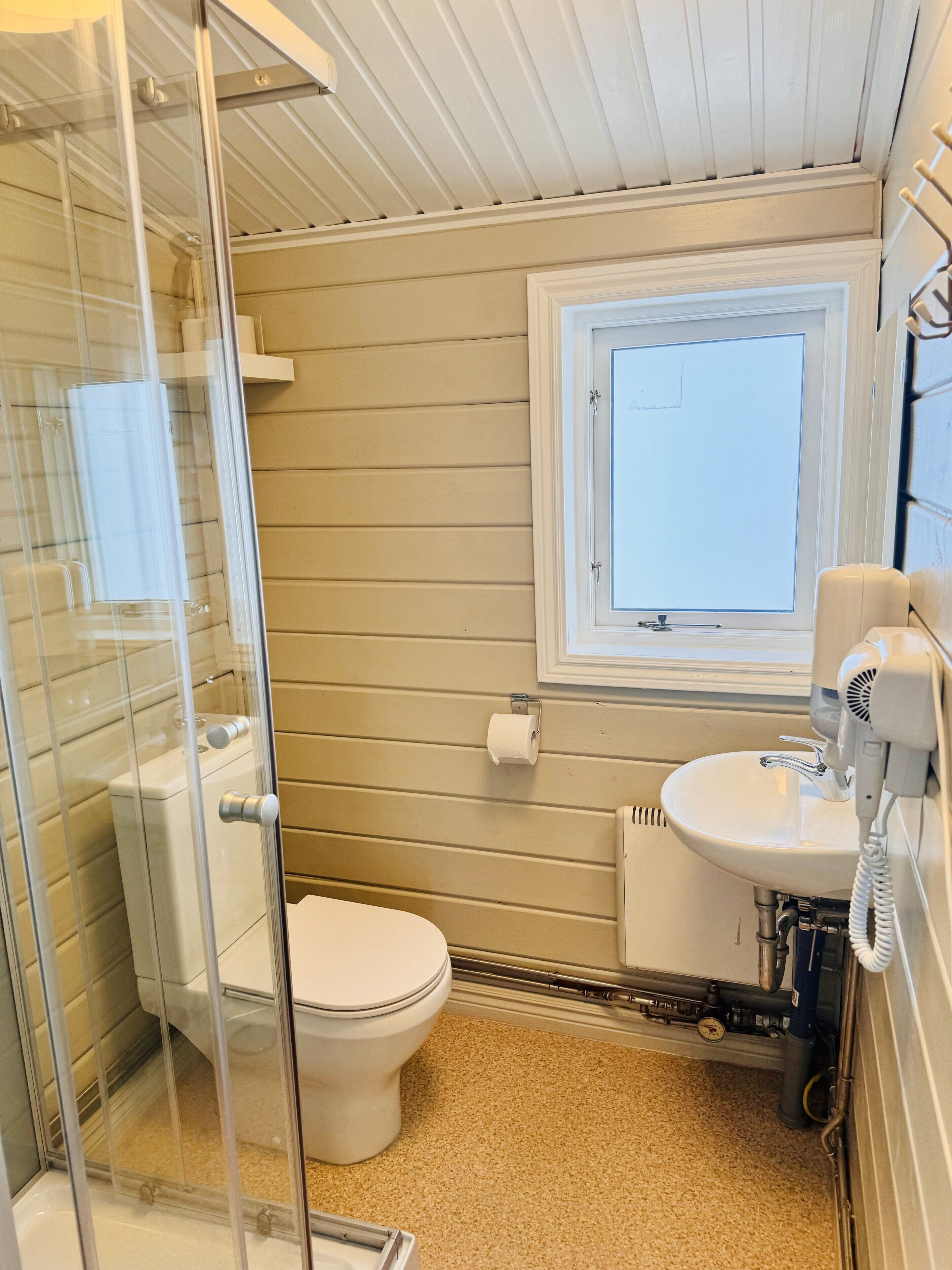 Ein Badezimmer mit Toilette, Waschbecken und Fenster.