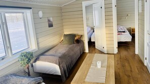 A compact, well-lit room with a bed, a small table, and a window. - Hellisholar Cottages (Rangárþing eystra)