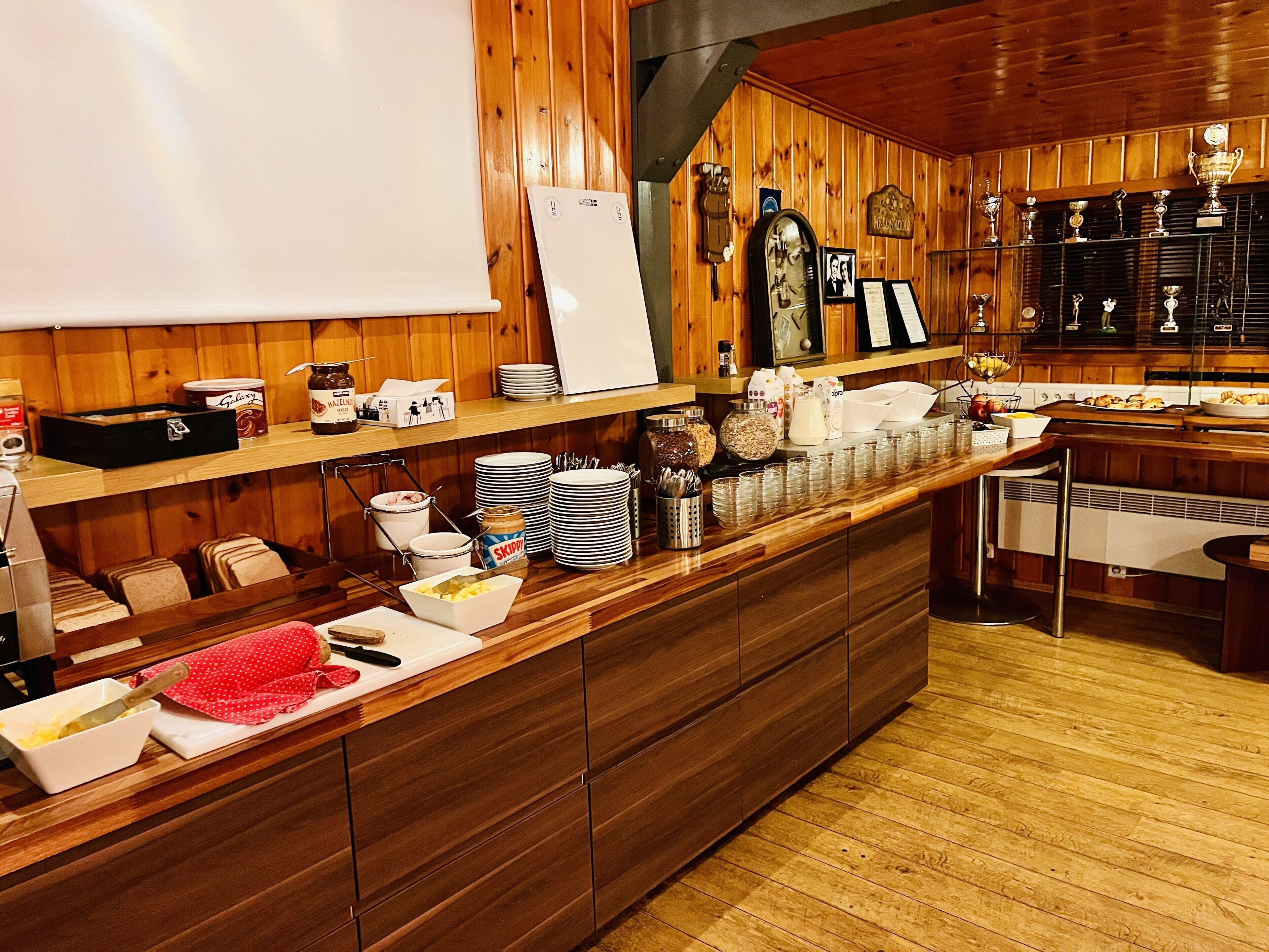 Une cuisine aux murs lambrés, avec un buffet proposant divers plats et ustensiles.