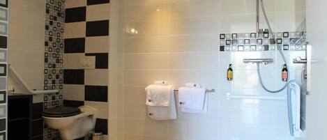 Un baño moderno con inodoro, ducha y lavabo.