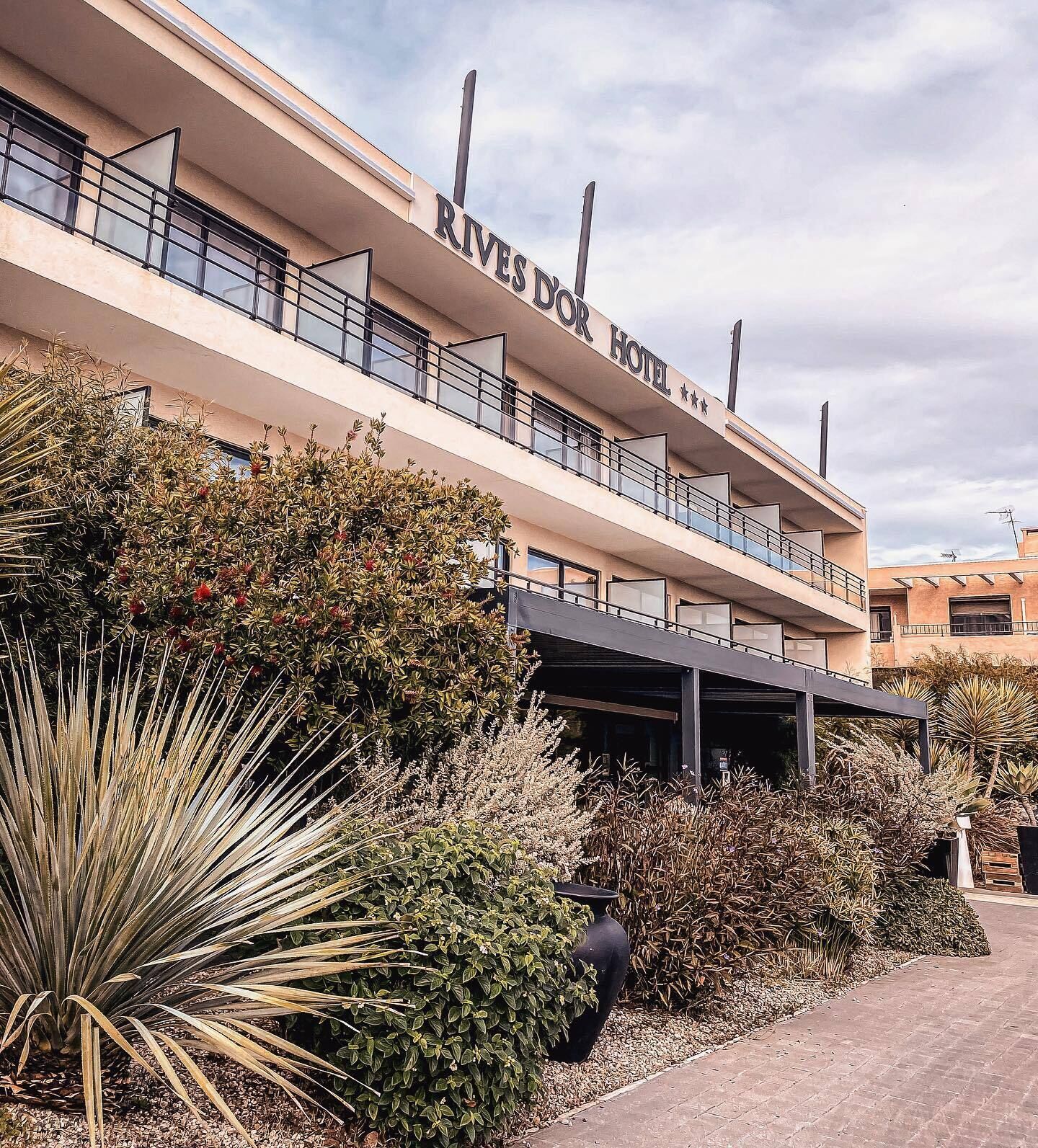 A hotel with a name sign 'RIVERS HOTEL' and a covered outdoor area.