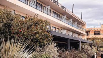 Un hôtel dont l’enseigne porte le nom « RIVERS HOTEL » et qui dispose d’un espace extérieur abrité.