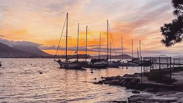 Un puerto deportivo con varios veleros amarrados al atardecer.