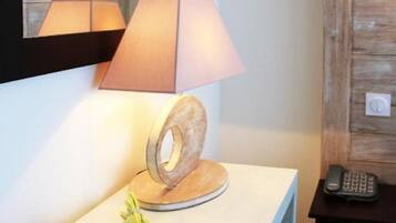 A room with a desk, a lamp, a telephone, and a bouquet of flowers.