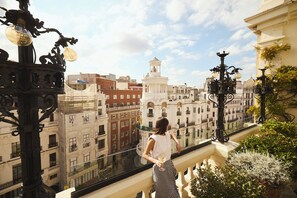 A balcony with a glass railing overlooking a cityscape with historic buildings. - The Principal Madrid, Small Luxury Hotels (Madrid)