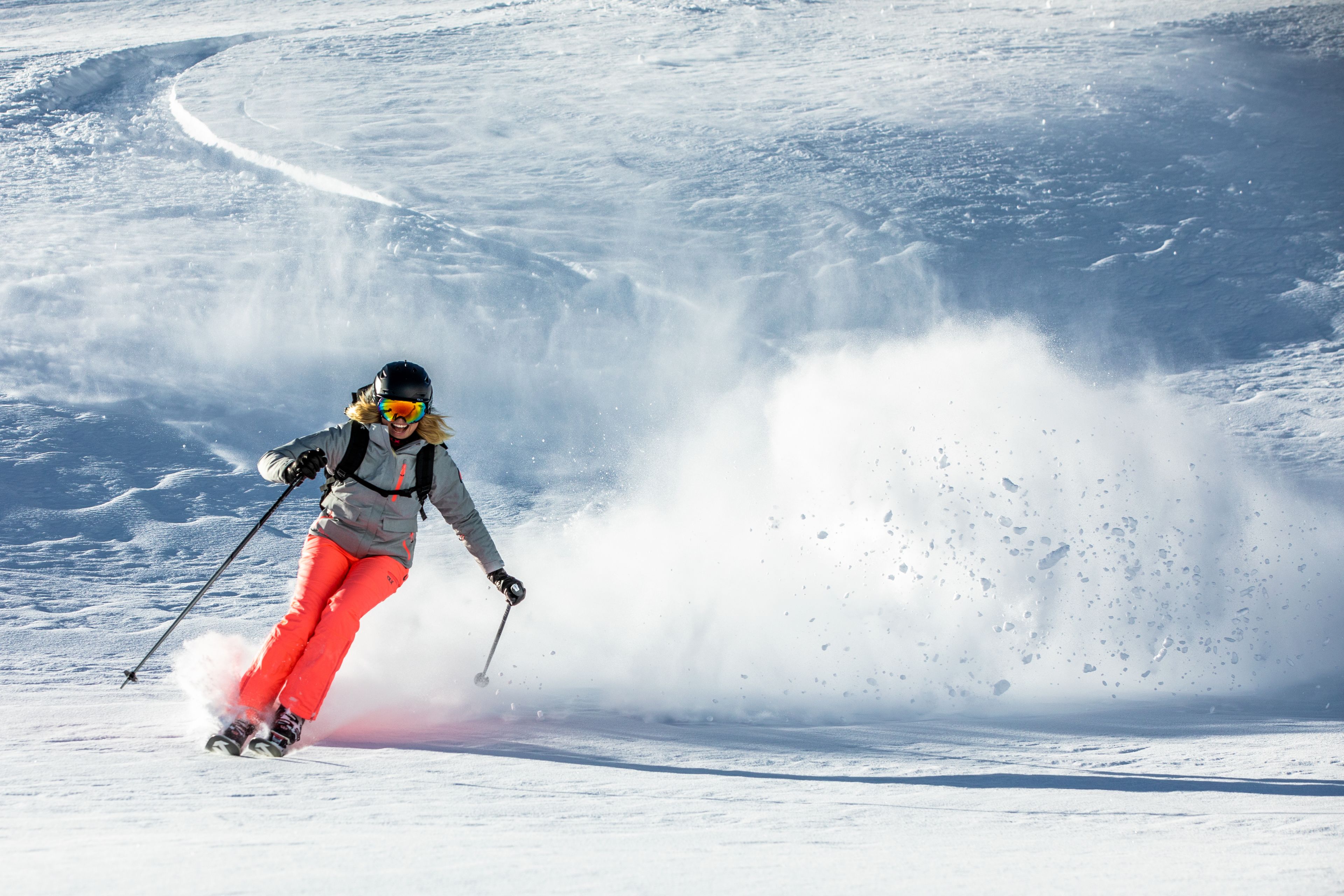 Eine Person fährt auf einem verschneiten Hang Ski.
