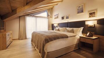 Une chambre avec un plafond en bois, un grand lit, une table de chevet et une commode.