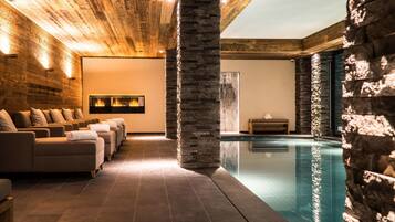 A spa area with massage chairs, a stone pillar, and a pool.
