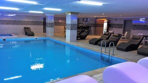A swimming pool with lounge chairs and a bar area.