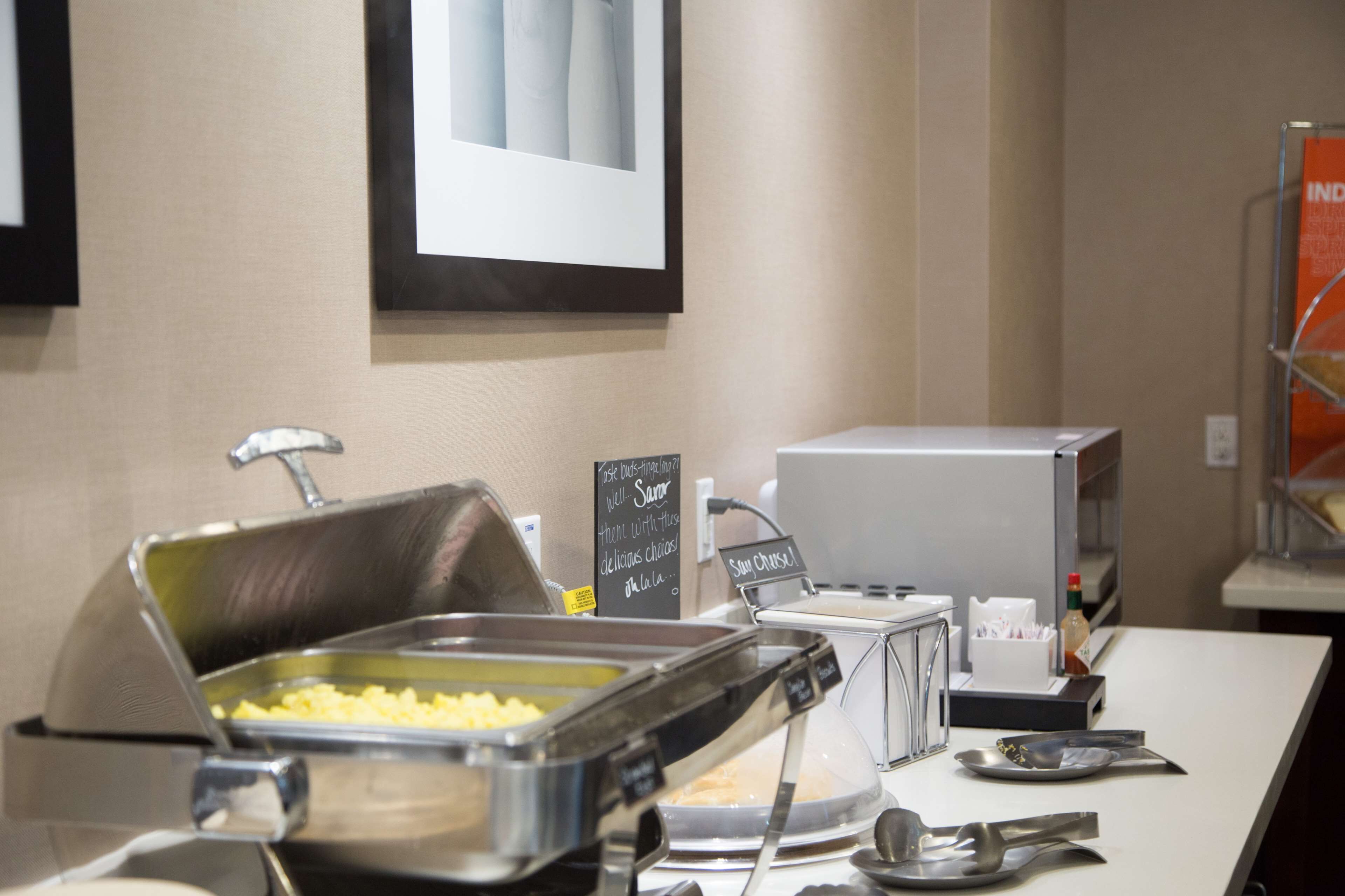 A buffet setup with various food items and serving utensils.