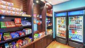 Ein Ausstellungsbereich für Snacks und Getränke mit Regalen voller verschiedener Snacks sowie einem Kühlbereich für Getränke.