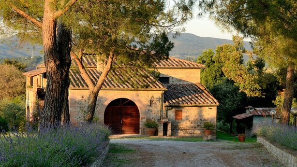 A rustic stone building with a tiled roof, an arched entrance, and a small porch. - Agriturismo Antico Podere Siliano (Citta della Pieve)