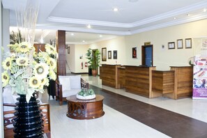 Welcome to our reception area, featuring a central desk, digital information board, and beautiful artwork.
