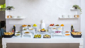 A buffet table with various food items and condiments. - Hotel Paradiso (Senigallia)