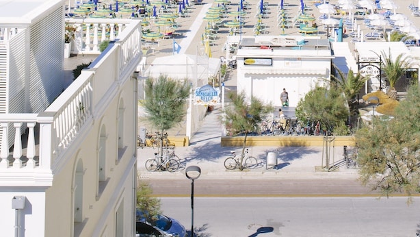 A coastal hotel with a beach view, outdoor seating, and bicycles. - Hotel Paradiso (Senigallia)