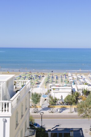 Un hotel frente al mar con vistas a la playa, terraza al aire libre y bicicletas.