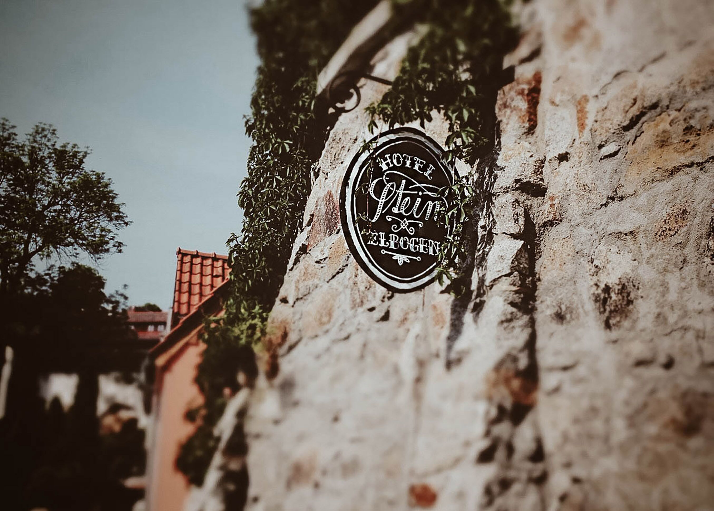 Un cartello d'epoca di un hotel con la scritta "Hotel Stein" su un muro di pietra.