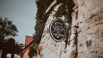 Un cartello d'epoca di un hotel con la scritta "Hotel Stein" su un muro di pietra.