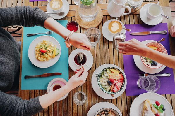 Una mesa de madera con diferentes platos, vasos y cubiertos, que sugiere un ambiente de comedor.