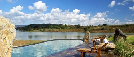 Een buitenzwembad en ligstoelen