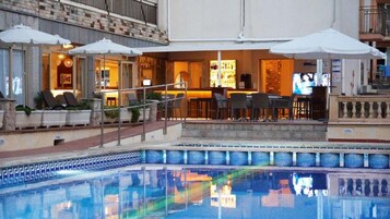 Una piscina al aire libre, tumbonas