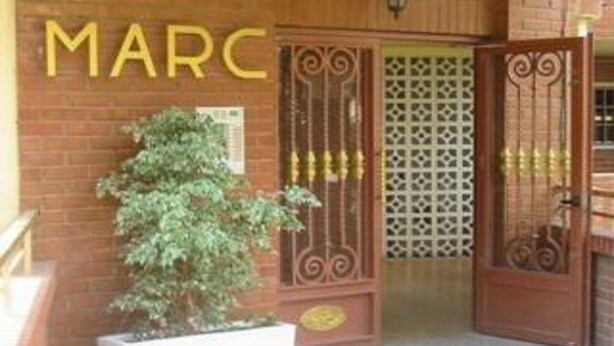 A building entrance with a large sign reading "MARC" and a decorative gate.