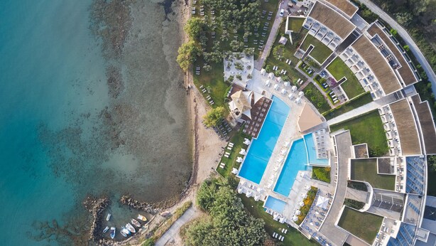 An aerial view of a resort with a large swimming pool, beachfront, and multiple buildings. - Atlantica Eleon Grand Resort - All Inclusive (Zakynthos)