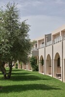 Un edificio a più livelli, con passerelle ad arco e un albero sullo sfondo.