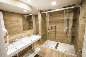 A modern bathroom with a glass-enclosed shower, a white sink, and wooden wall panels.
