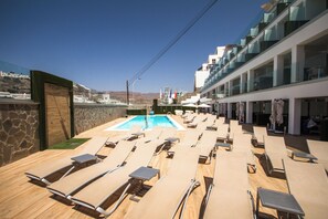 A poolside area with sun loungers, a swimming pool, and a view of a mountainous landscape. - IG Nachosol Atlantic & Yaizasol by Servatur (Mogan)