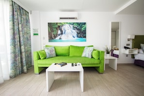 A modern living room with a green sofa, a white coffee table, and a painting of a waterfall. - IG Nachosol Atlantic & Yaizasol by Servatur (Mogan)